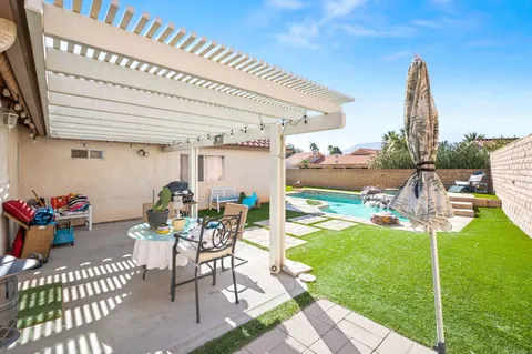 a view of a patio with a table and chairs and potted plants