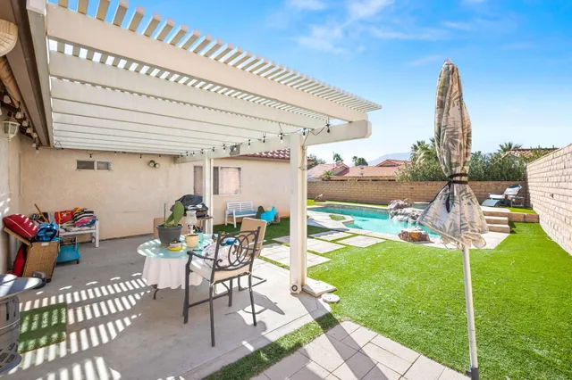 a view of a patio with a table and chairs and potted plants