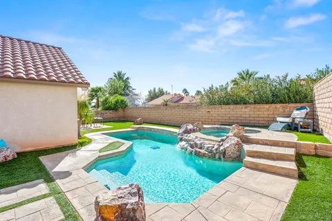 a view of a patio with table and chairs with wooden fence