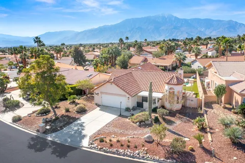 an aerial view of a house with a mountain