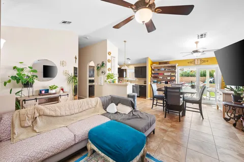 a living room with furniture kitchen view and a large window