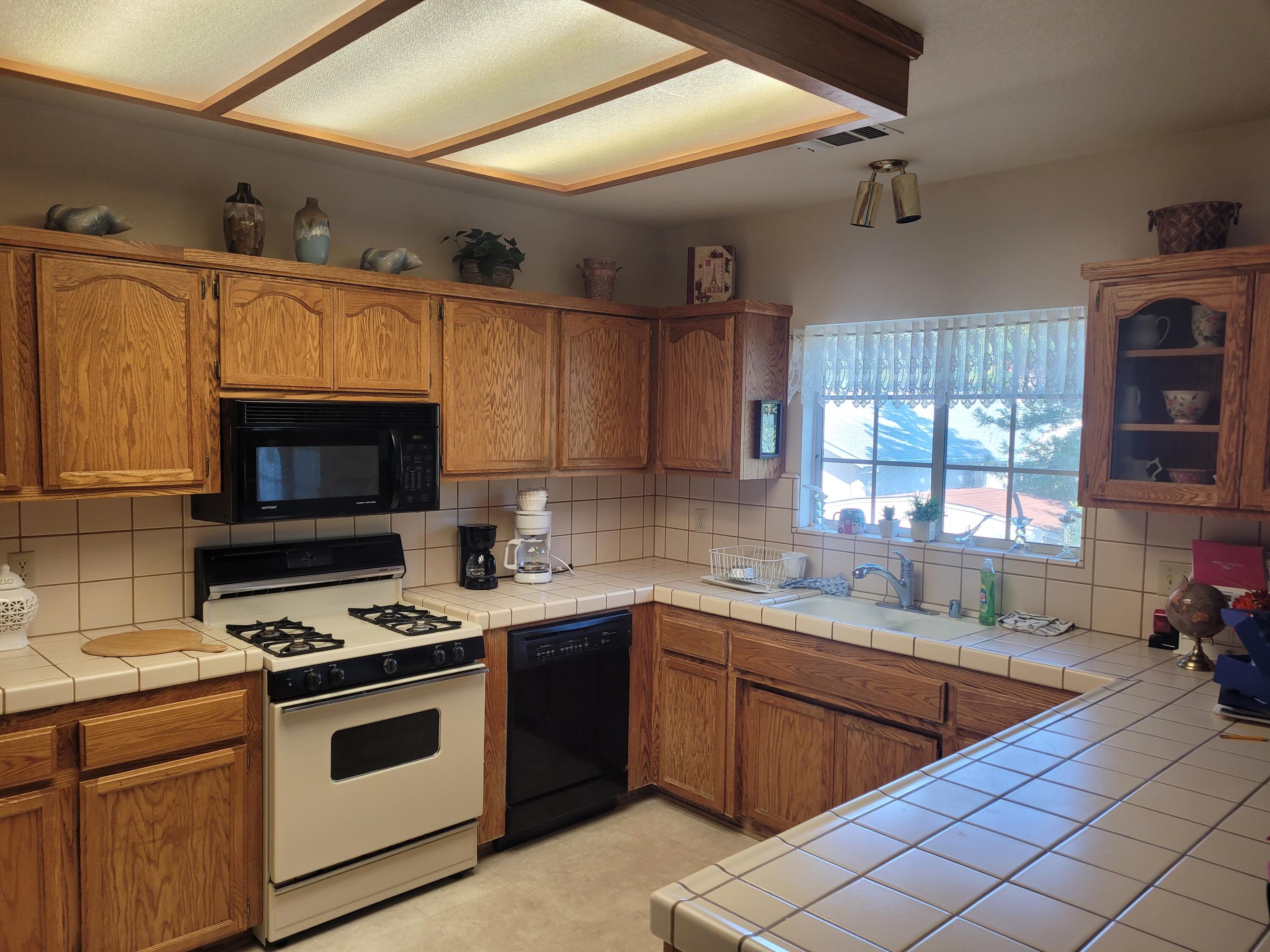 4979 Tralee Lane Redding, CA 96001 - Photo 8 of 19 a kitchen with stainless steel appliances a stove sink and microwave