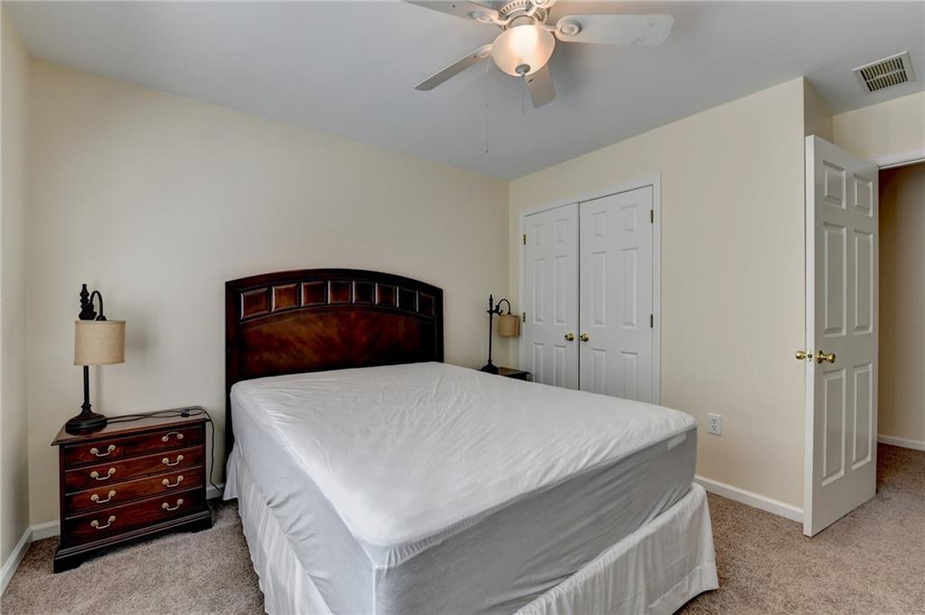 1031 Riverside Road Sugar Hill, GA 30518 - Photo 47 of 109 a bedroom with a bed and a chandelier