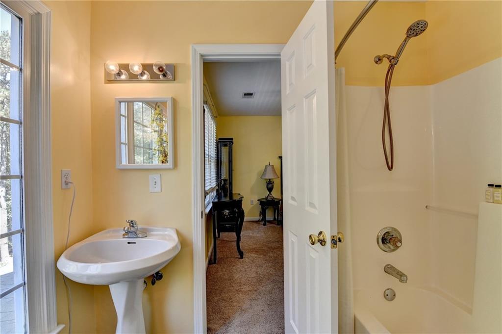 1031 Riverside Road Sugar Hill, GA 30518 - Photo 57 of 109 a bathroom with a sink a mirror and a shower