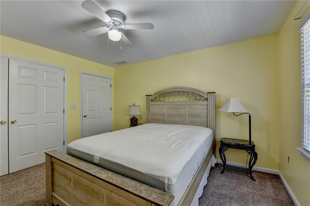 1031 Riverside Road Sugar Hill, GA 30518 - Photo 60 of 109 a bedroom with a bed and a chandelier