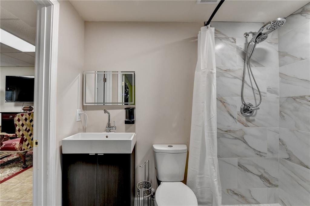 1031 Riverside Road Sugar Hill, GA 30518 - Photo 75 of 109 a bathroom with a sink toilet and shower
