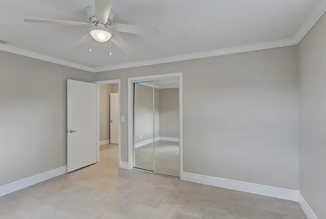 an empty room with a ceiling fan and a window