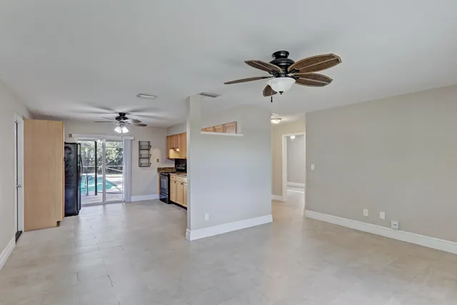a view of a livingroom with a ceiling fan window and a kitchen