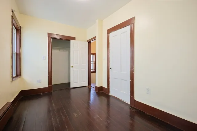 an empty room with wooden floor and a window