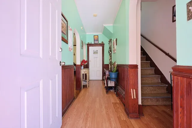 a view of a hallway with wooden floor and staircase