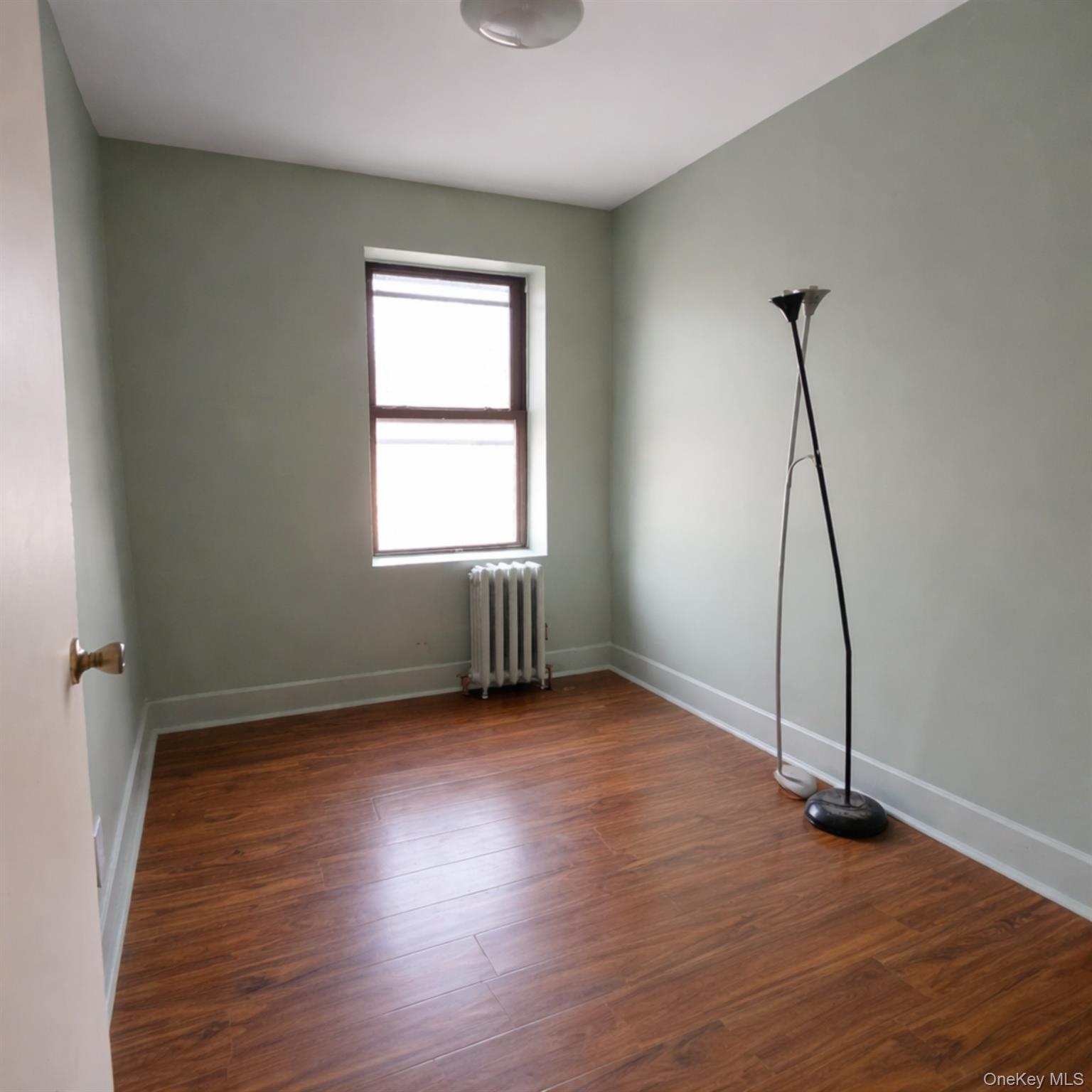 91-45 85th Street Queens, NY 11421 - Photo 5 of 15 an empty room with wooden floor and windows