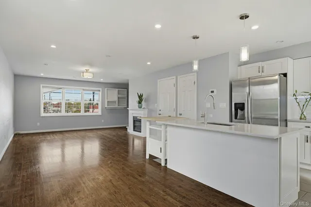 a large kitchen with stainless steel appliances kitchen island a large counter top and a stove top oven