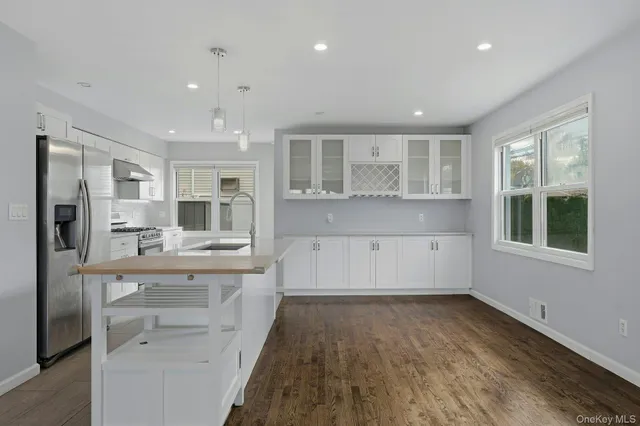 a large kitchen with kitchen island a sink stainless steel appliances and cabinets