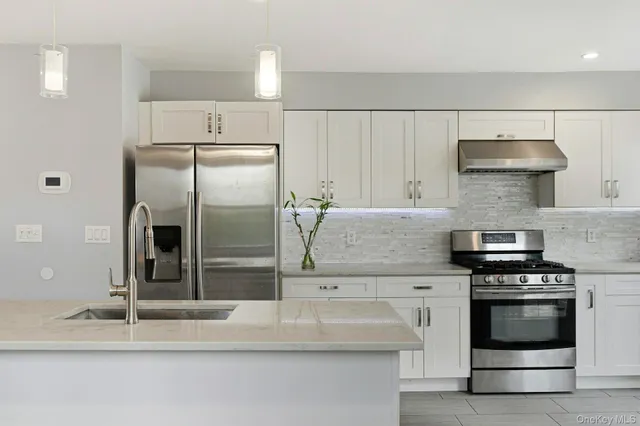 a kitchen with granite countertop a stove and a refrigerator