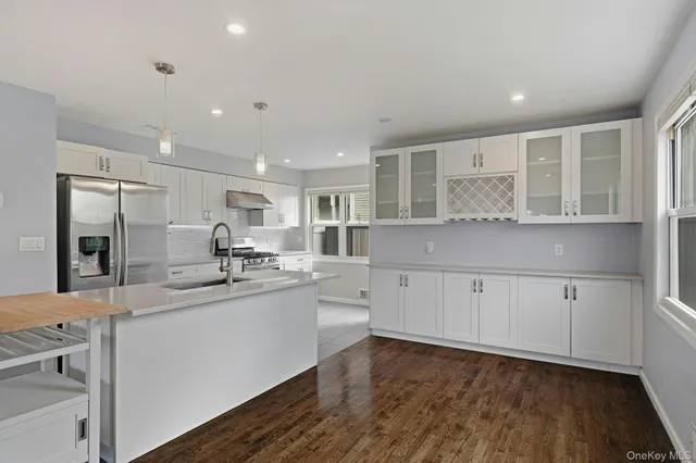 a kitchen with white cabinets and sink