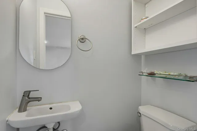 a bathroom with a sink a toilet and a mirror