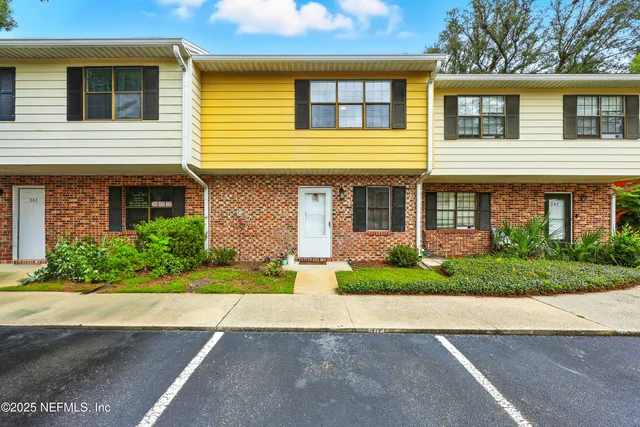 a front view of a house with a yard and potted plants