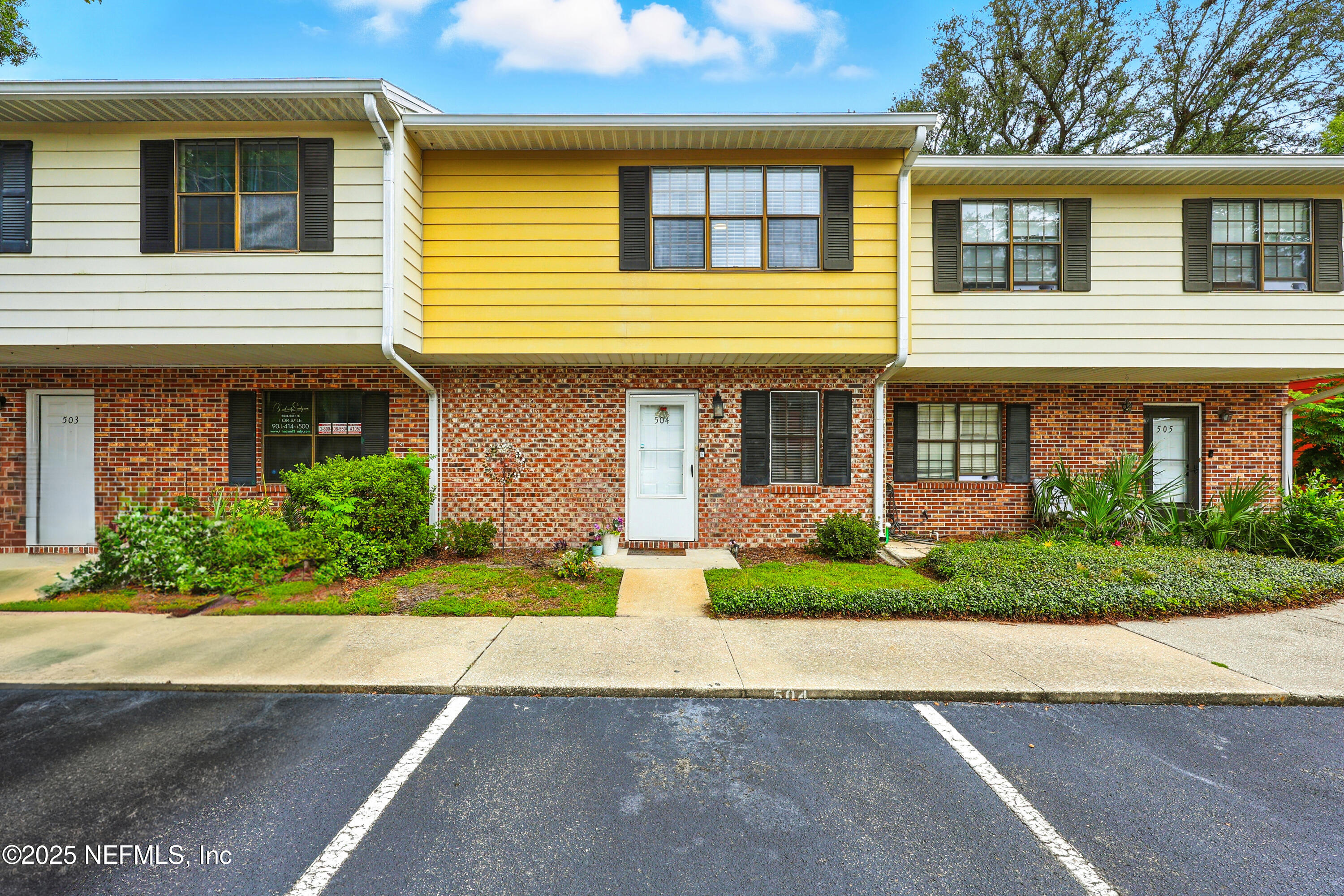 a front view of a house with a yard and potted plants