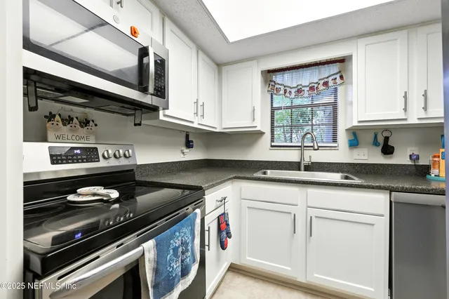 a kitchen with stainless steel appliances granite countertop a sink and a stove