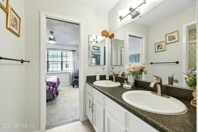 a en suite bathroom with a double vanity sink and a mirror