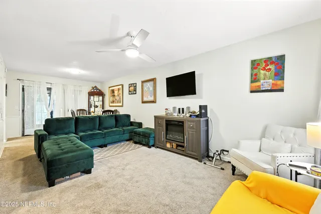 a living room with furniture a flat screen tv and a fireplace