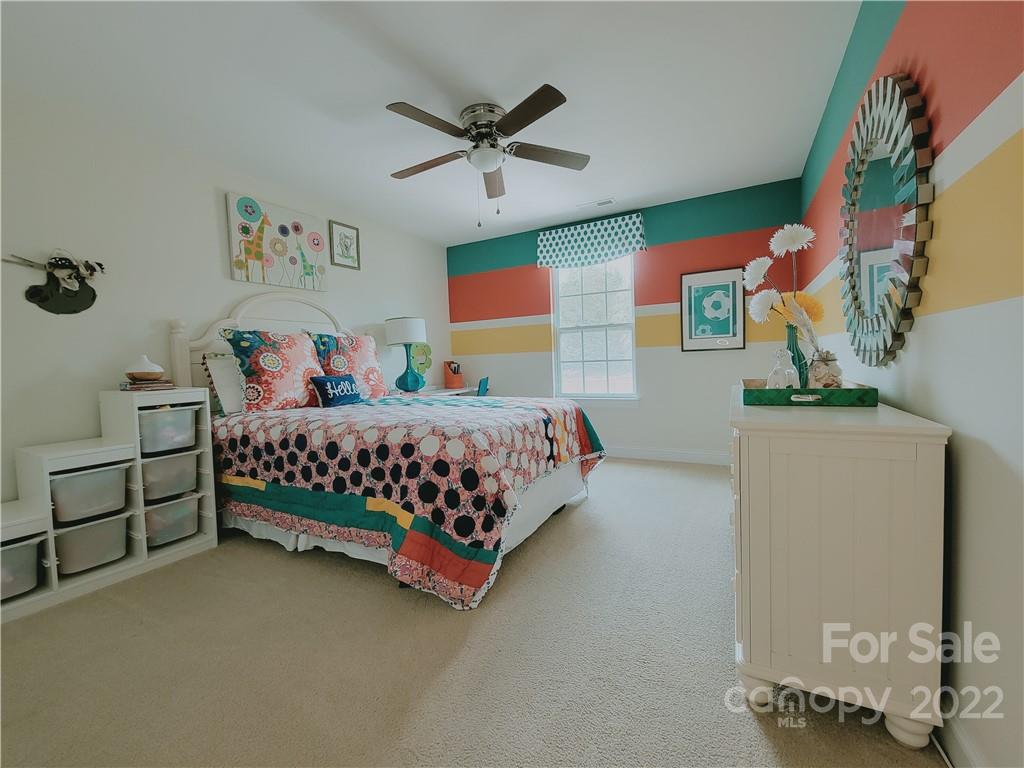 7716 West Berkeley Road Denver, NC 28037 - Photo 17 of 33 a bedroom with a bed and a chandelier