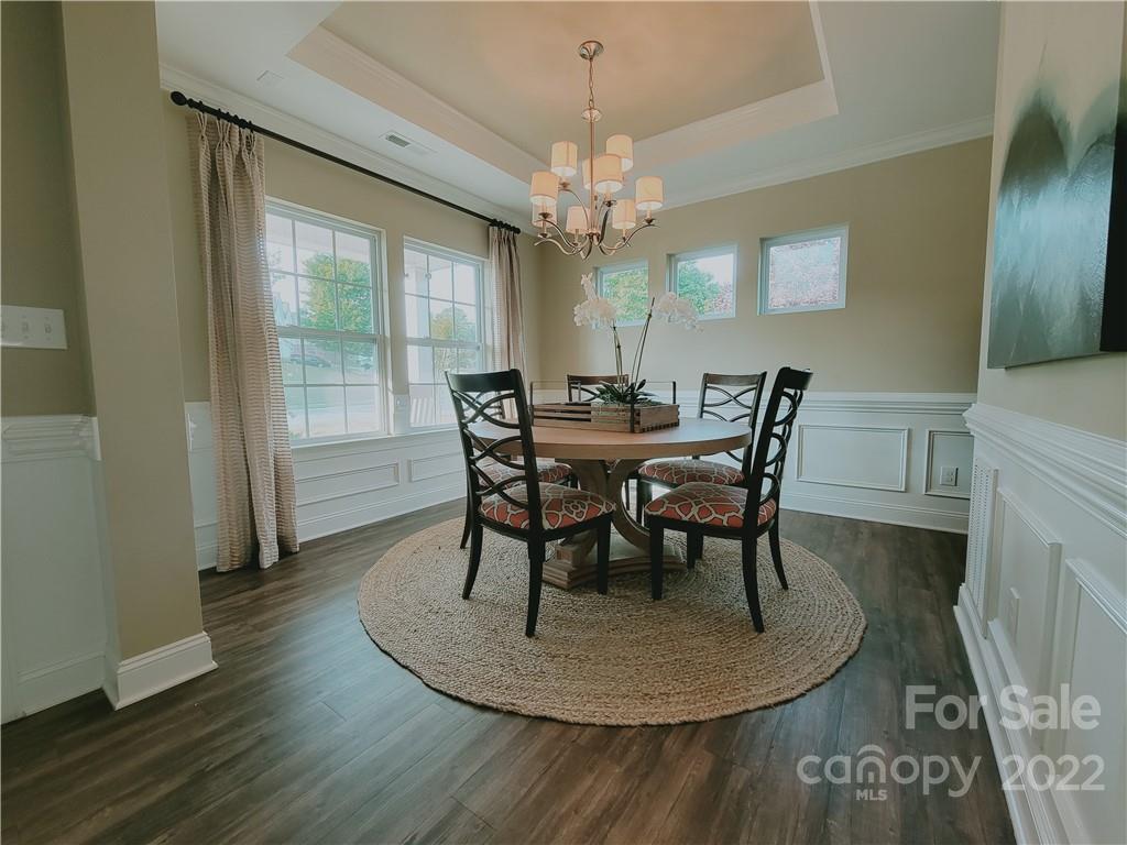7716 West Berkeley Road Denver, NC 28037 - Photo 3 of 33 a dining room with furniture a chandelier and wooden floor