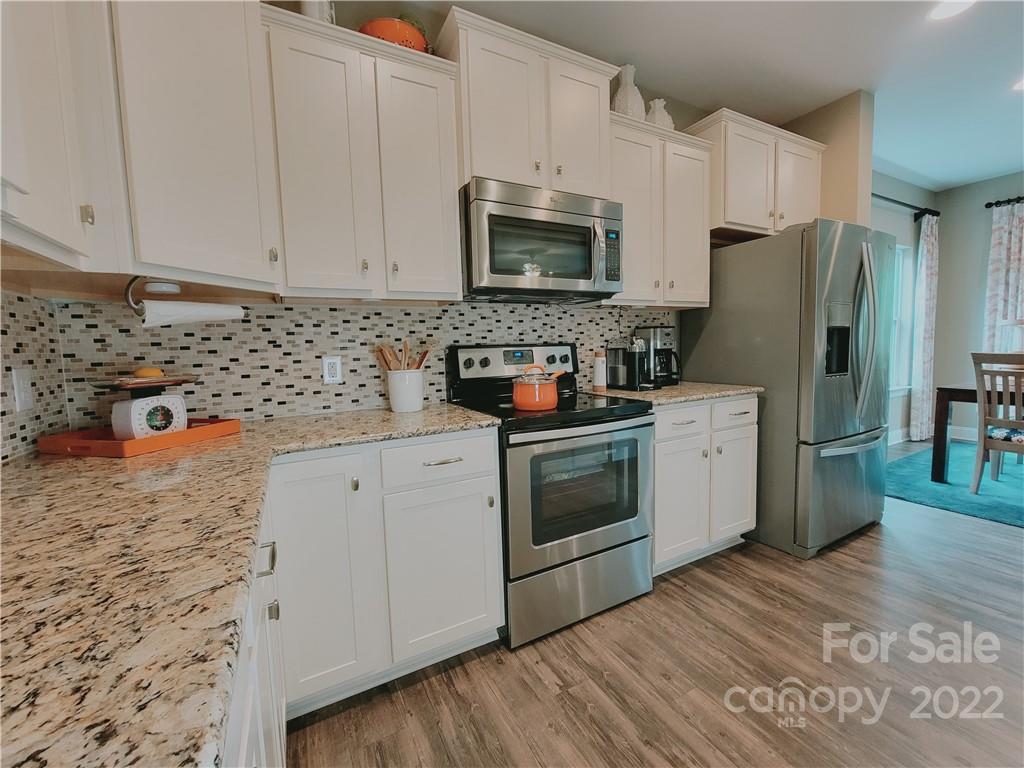 7716 West Berkeley Road Denver, NC 28037 - Photo 5 of 33 a kitchen with stainless steel appliances a stove microwave and refrigerator