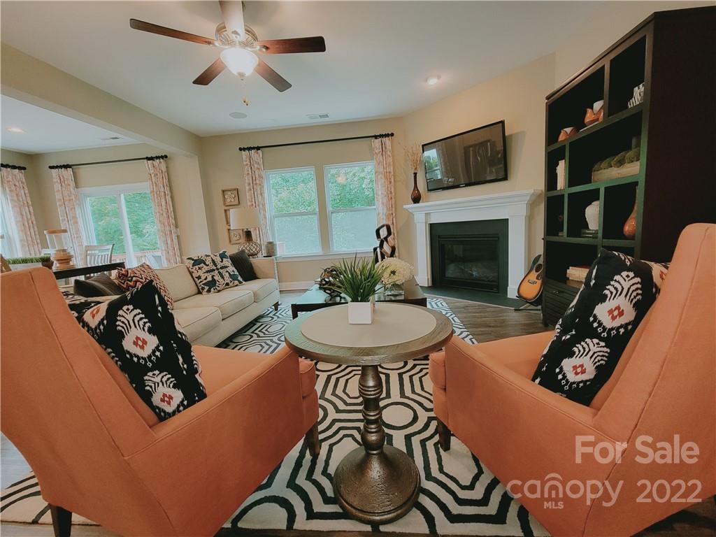 7716 West Berkeley Road Denver, NC 28037 - Photo 8 of 33 a living room with furniture a fireplace and a flat screen tv