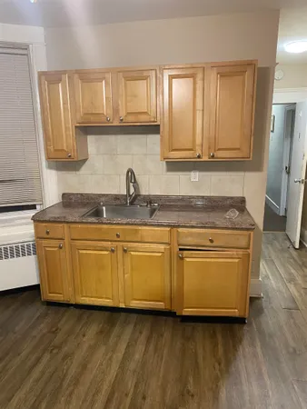 a kitchen with granite countertop wooden cabinets and a sink