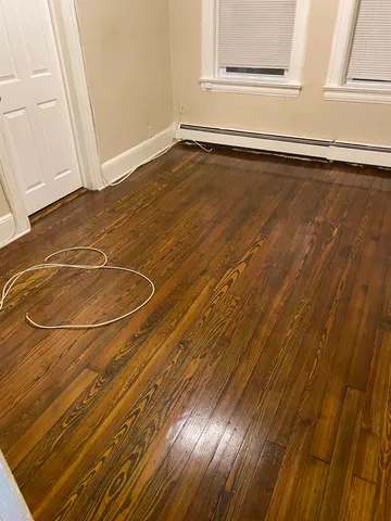 a view of a room with wooden floor and door