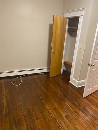 a view of a room with wooden floor and door