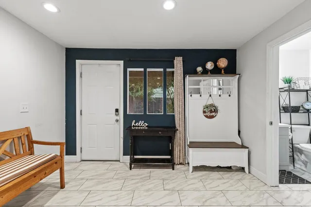 a kitchen with stainless steel appliances granite countertop a refrigerator a stove a sink a dining table and chairs