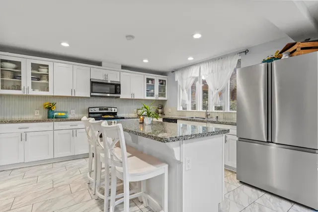 a front view of a house with a yard and lake view