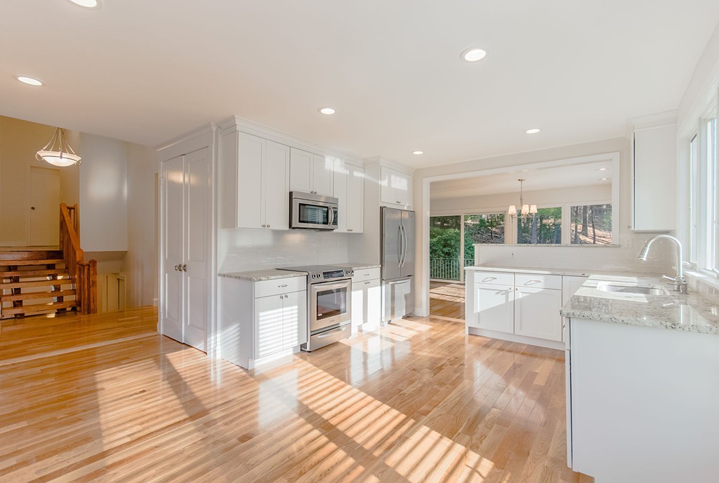 264 Country Way Needham, MA 02492 - Photo 12 of 29 a kitchen with stainless steel appliances kitchen island granite countertop a refrigerator and a sink