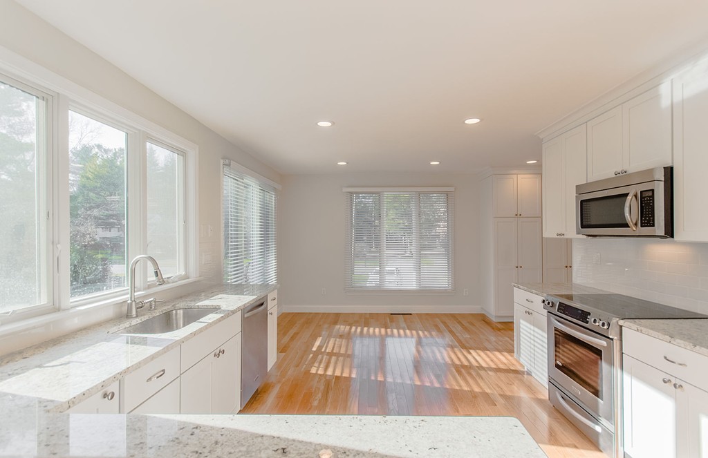264 Country Way Needham, MA 02492 - Photo 15 of 29 a kitchen with granite countertop a stove a sink and a microwave