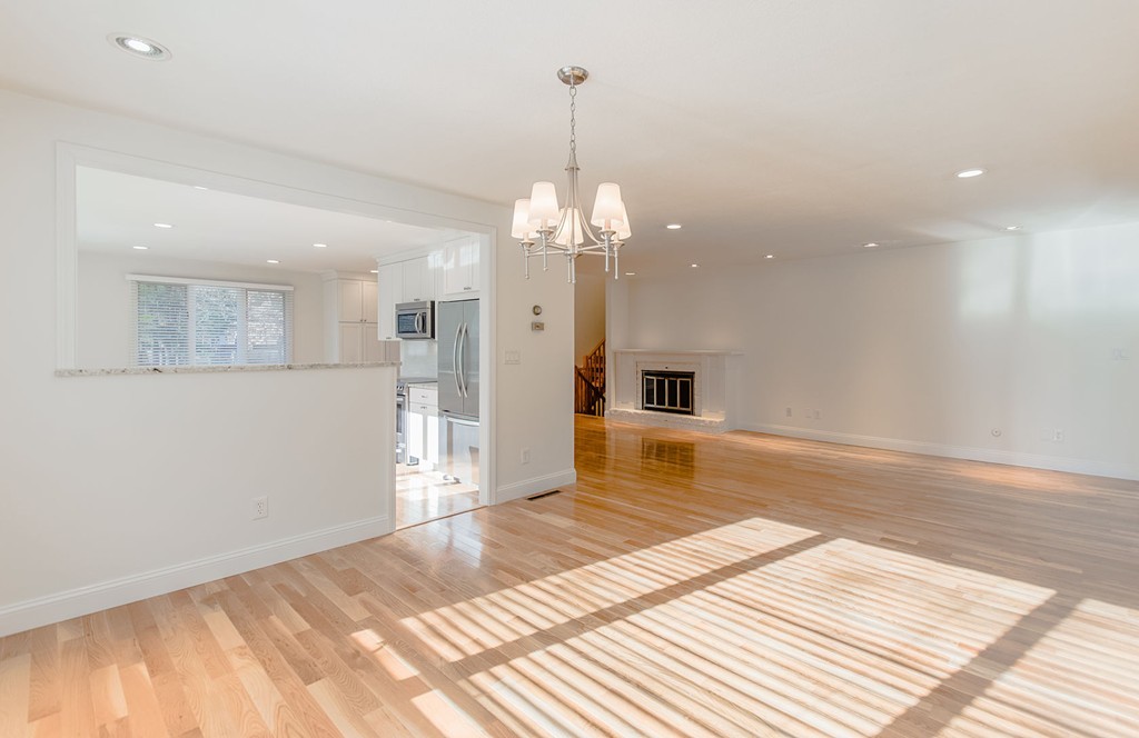 264 Country Way Needham, MA 02492 - Photo 9 of 29 a view of a livingroom with a chandelier fan and kitchen view