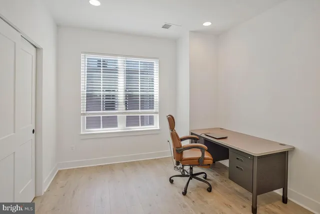 a view of a workspace with furniture and a window