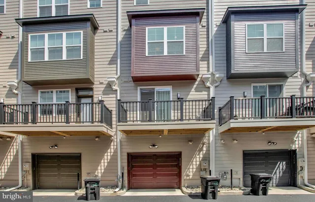 a front view of a building with lot of cars and trees