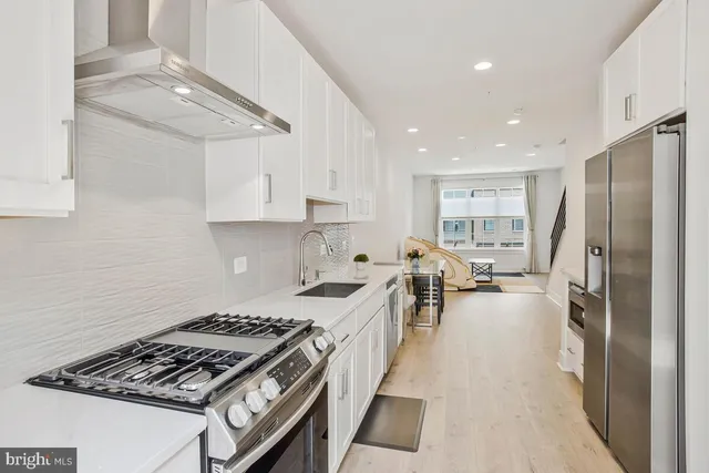 a kitchen with sink stove refrigerator and cabinets
