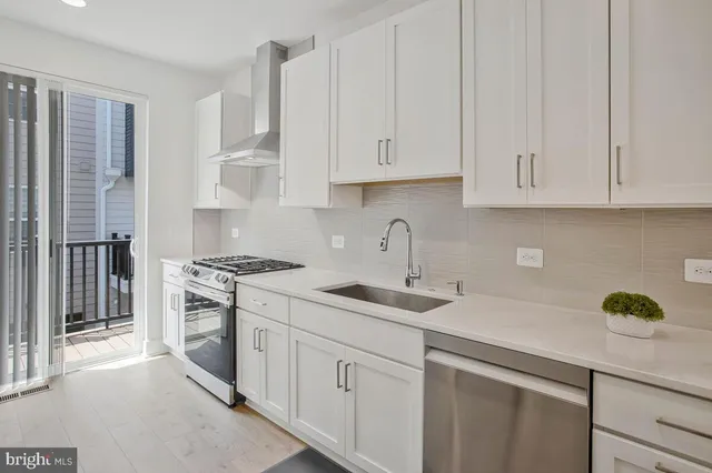 a kitchen with stainless steel appliances granite countertop white cabinets a sink and dishwasher
