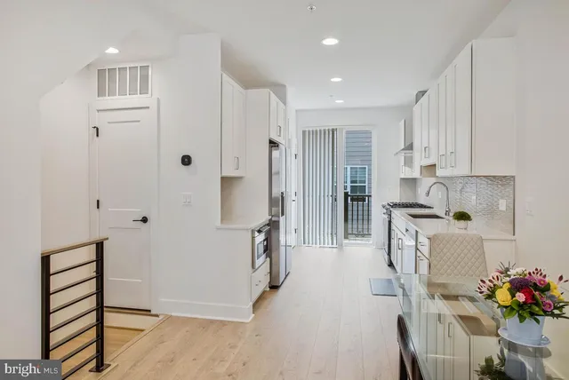 a kitchen with white cabinets and stainless steel appliances