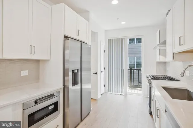 a kitchen with stainless steel appliances granite countertop a refrigerator and a sink