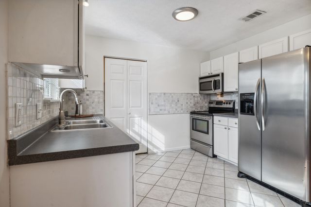 a kitchen with kitchen island a sink appliances and cabinets