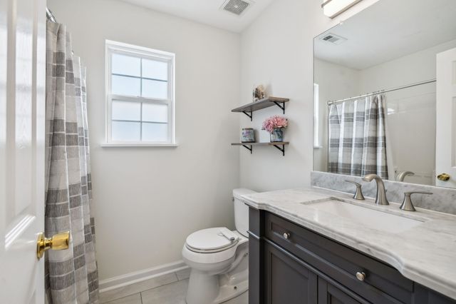 a bathroom with a granite countertop sink a toilet and a shower