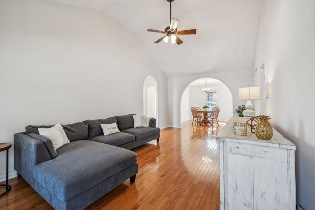 a living room with furniture a dining table and a chandelier