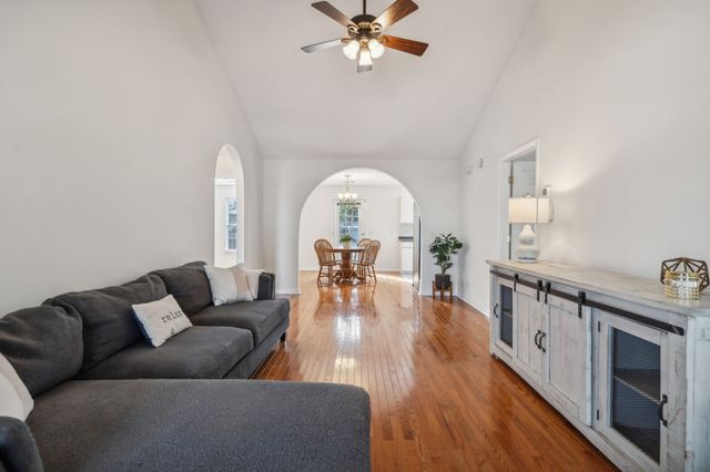 a living room with furniture a fireplace and wooden floor