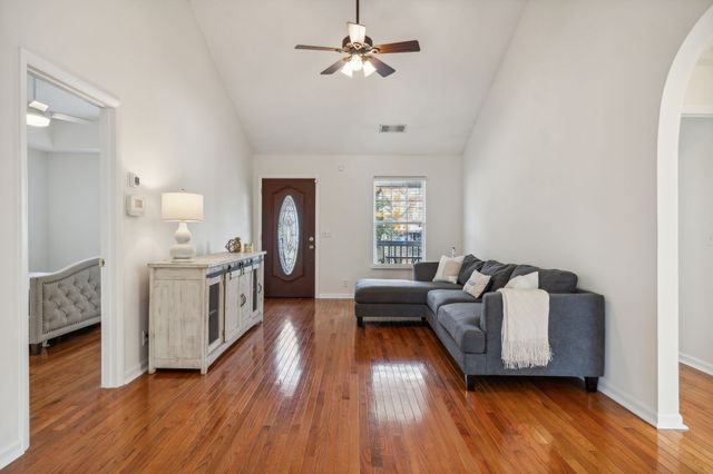 a living room with furniture and a wooden floor