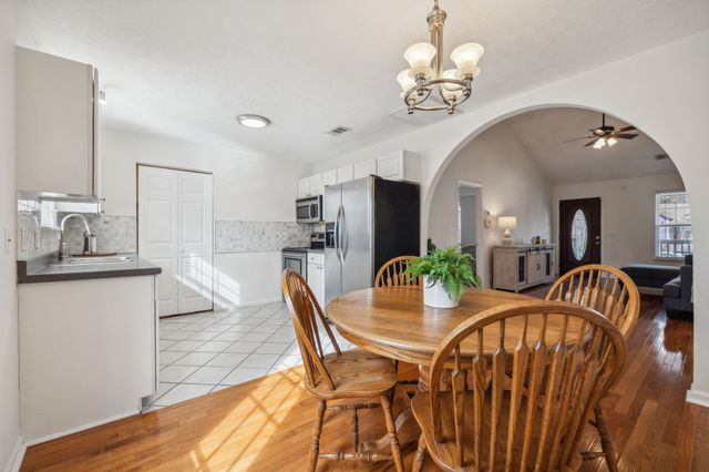 a view of a dining room with furniture a chandelier and wooden floor