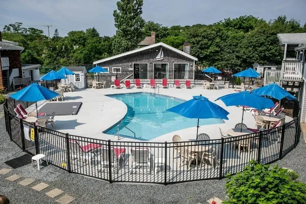 a view of a patio with table and chairs under an umbrella with wooden fence
